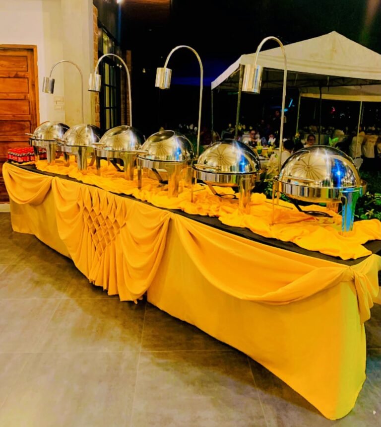Cafe Esquinita buffet line with chafing dishes and gold table drapes at an evening event