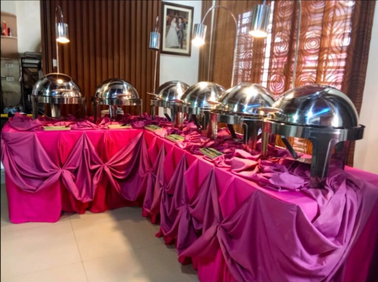 Cafe Esquinita buffet line with chafing dishes and pink table drapes