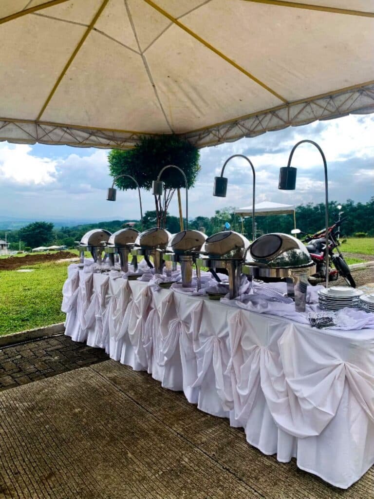 Cafe Esquinita catering buffet under a tent with a hillside view