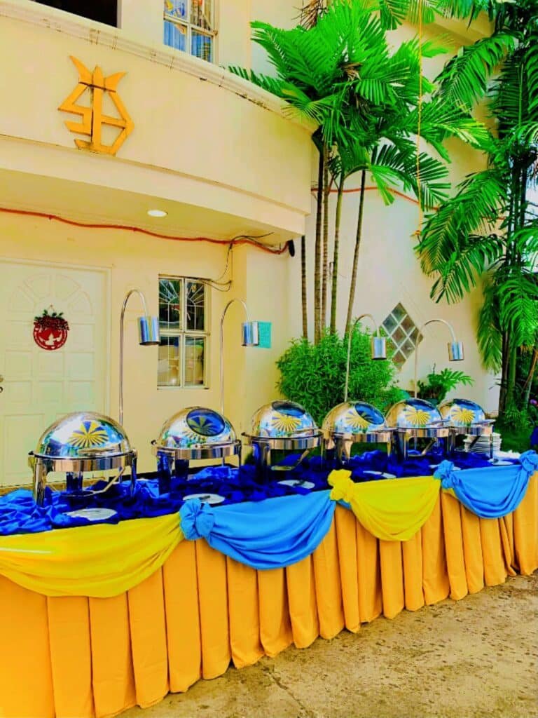 Cafe Esquinita outdoor buffet with chafing dishes and blue and yellow drapes