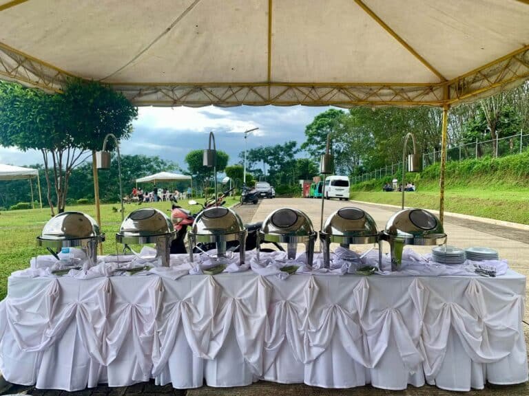 Cafe Esquinita outdoor catering buffet under a tent with white table skirting