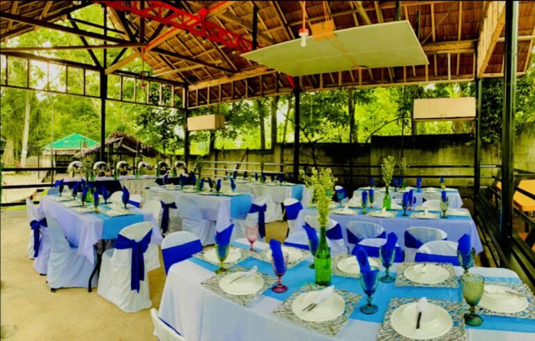 Cafe Esquinita banquet tables with blue accents set up in an open pavilion
