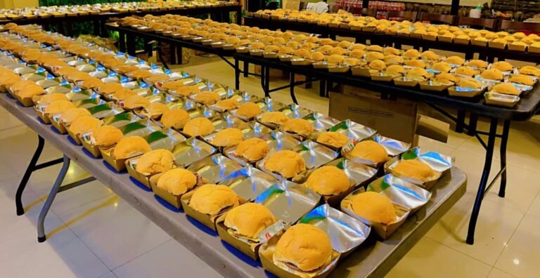 Tables of Cafe Esquinita snack packs with burgers in boxes ready for a large group order in Malaybalay City